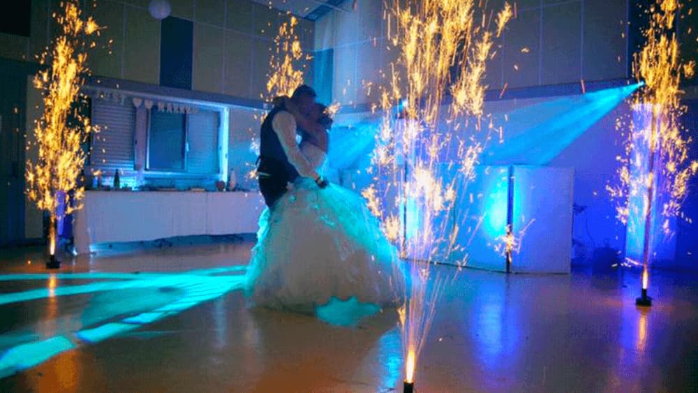 couple de mariés dansent entourés de jets de scène dans une salle de fête